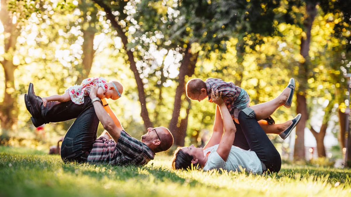 A joyful family enjoying playtime in a sunny park, capturing moments of laughter and happiness.